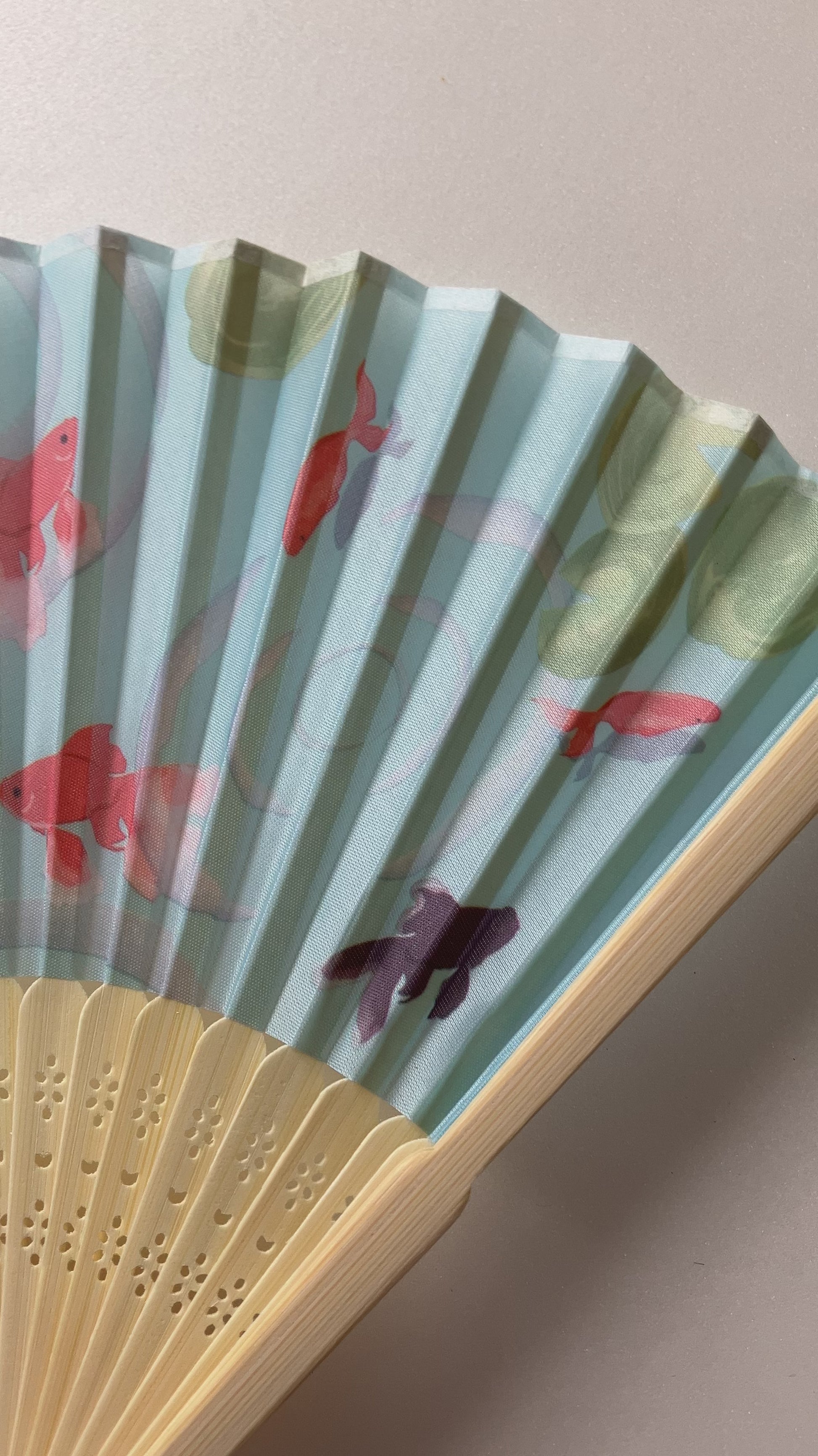 Visual showcase of Japanese summer fan featuring swimming goldfish artwork