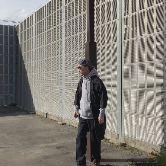 Full-body look featuring an early Showa Japanese Noragi jacket styled with casual streetwear, highlighting the indigo stripes, patchwork sleeves, and long hem.