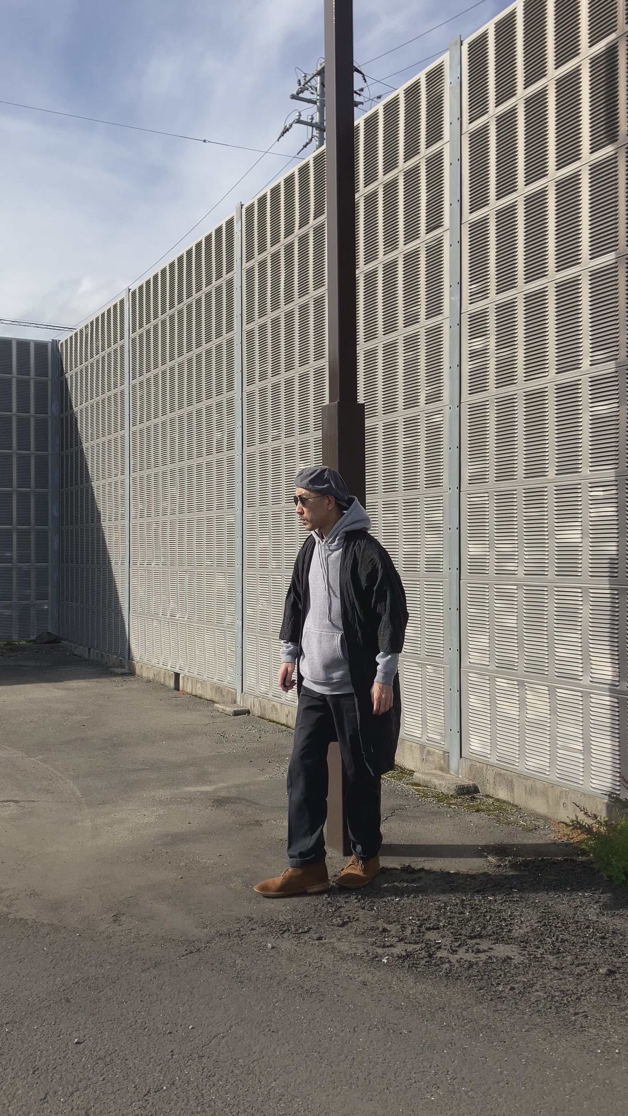 Full-body look featuring an early Showa Japanese Noragi jacket styled with casual streetwear, highlighting the indigo stripes, patchwork sleeves, and long hem.