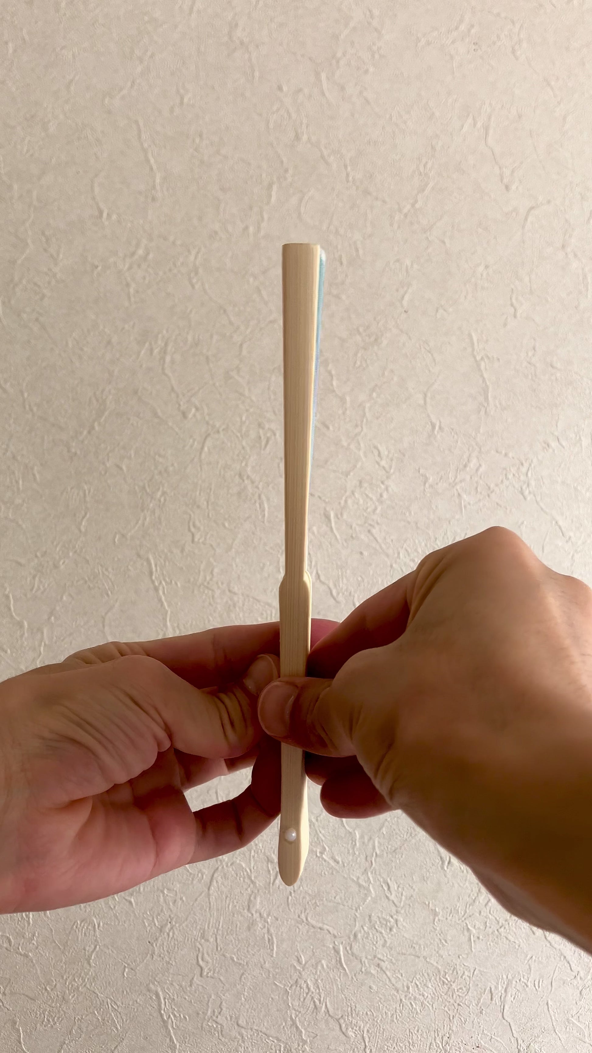 Close-up video of a Japanese folding fan opening to reveal goldfish and demekin design