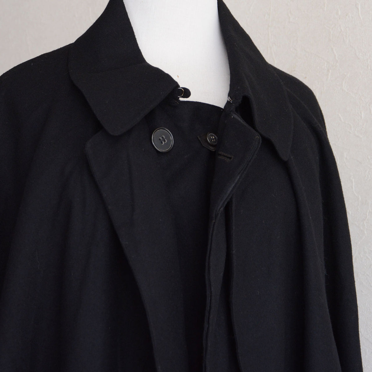 Collar, black buttons and metal neck fastening on a Matsuzakaya black wool Japanese vintage tonbi coat