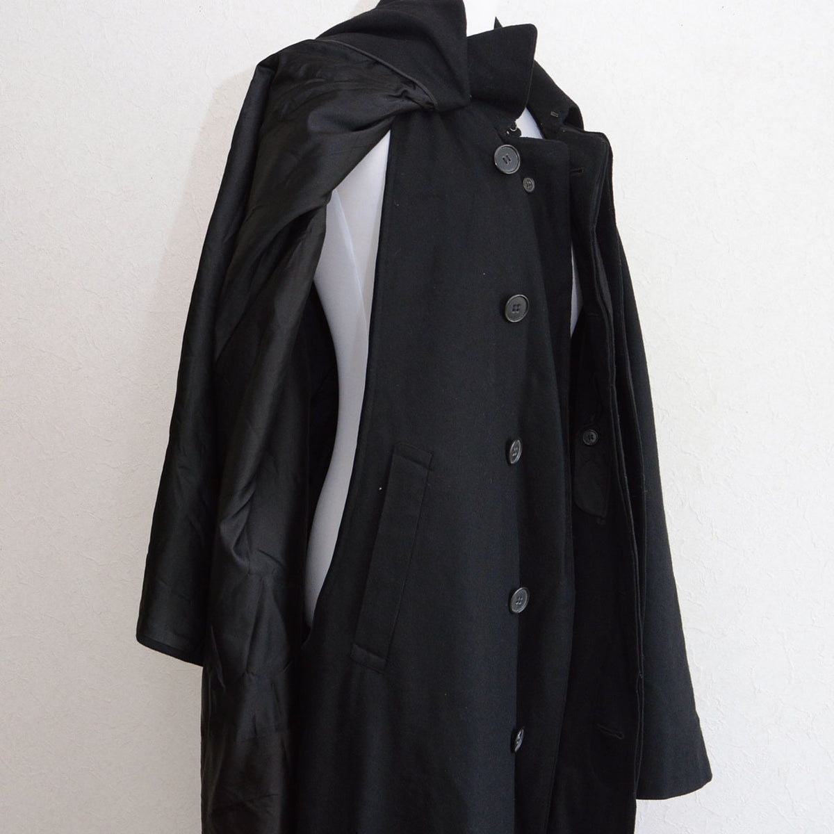 Arm opening, front buttons, side pocket and black cape lining of a Matsuzakaya black wool tonbi coat