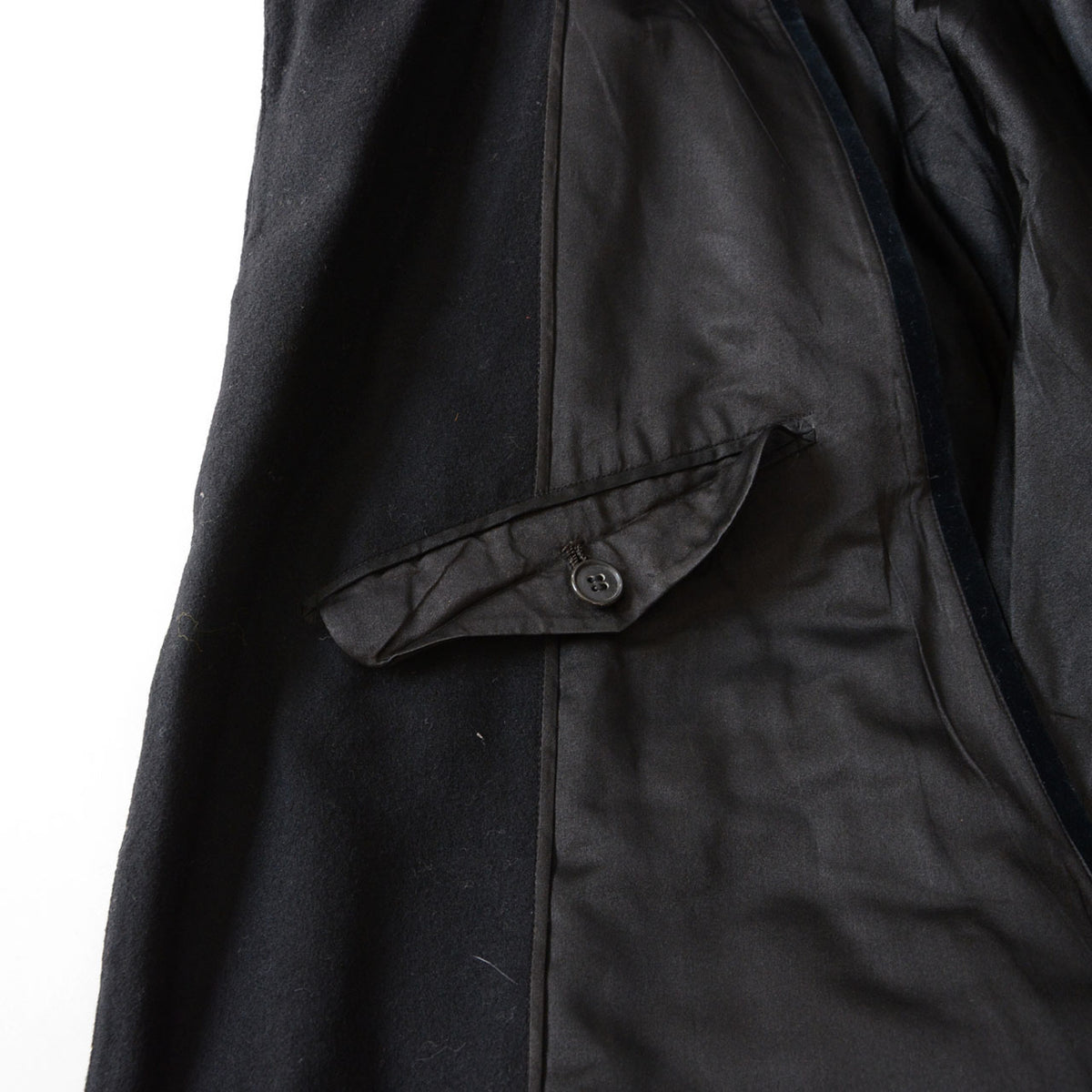 Horizontal flap pocket with button on the black lining of a Matsuzakaya Japanese vintage tonbi coat