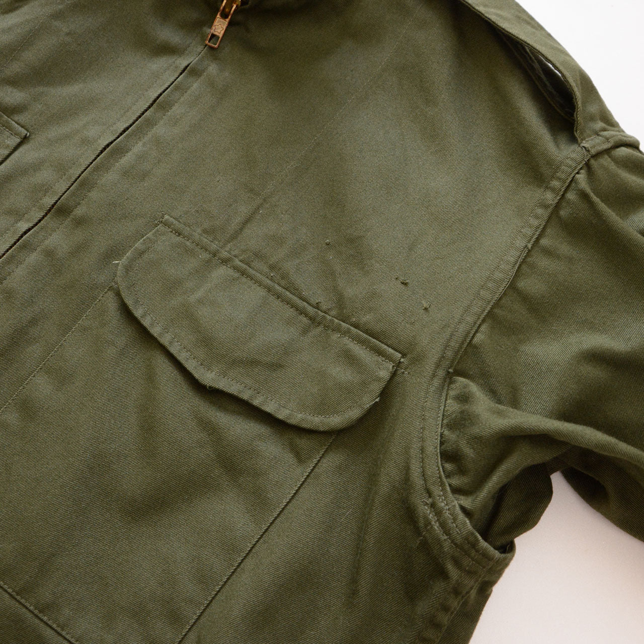 Flap pocket with patch removal trace above, underarm ventilation opening visible, JGSDF Type 65 work jacket
