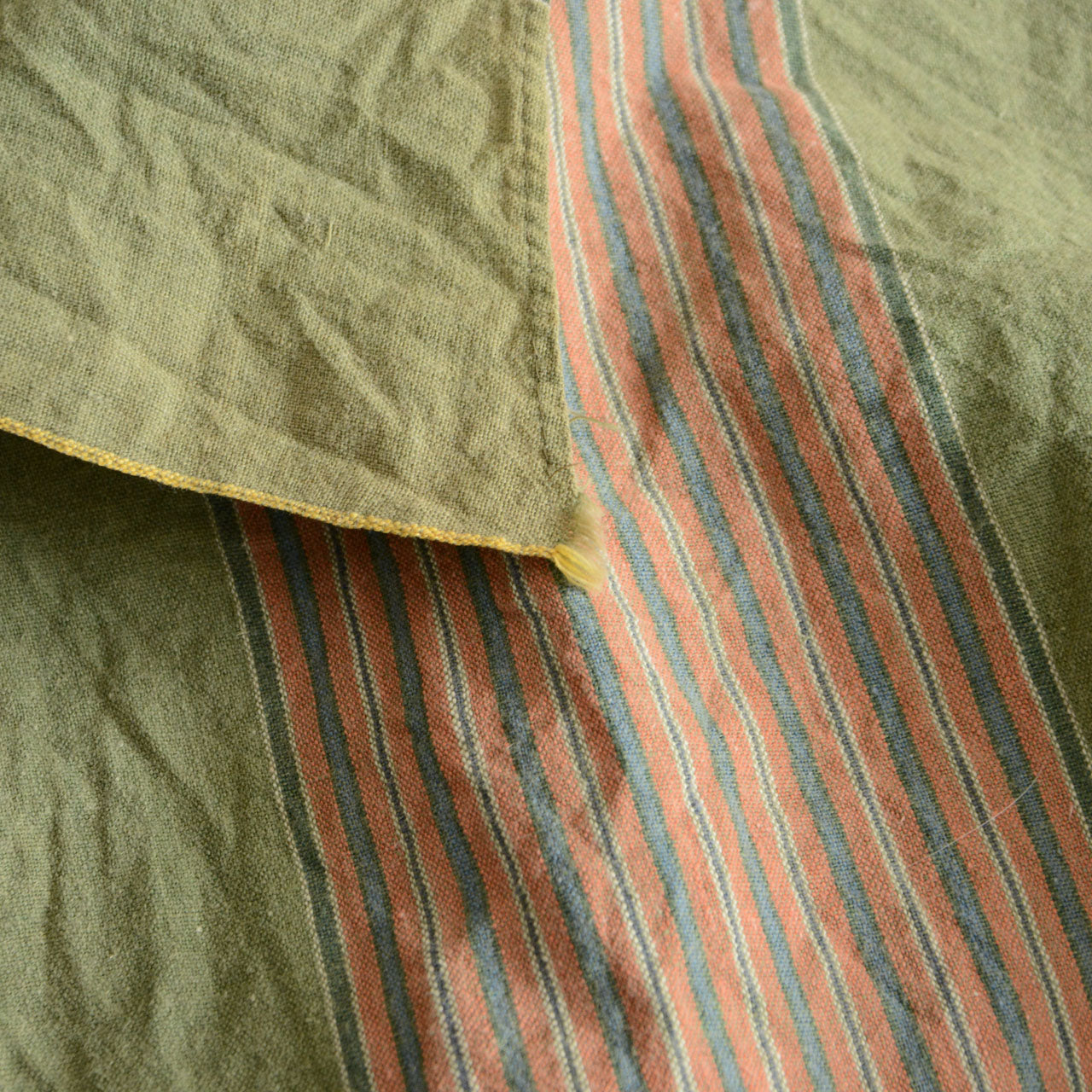 Green striped vintage fabric used as table cover or display cloth