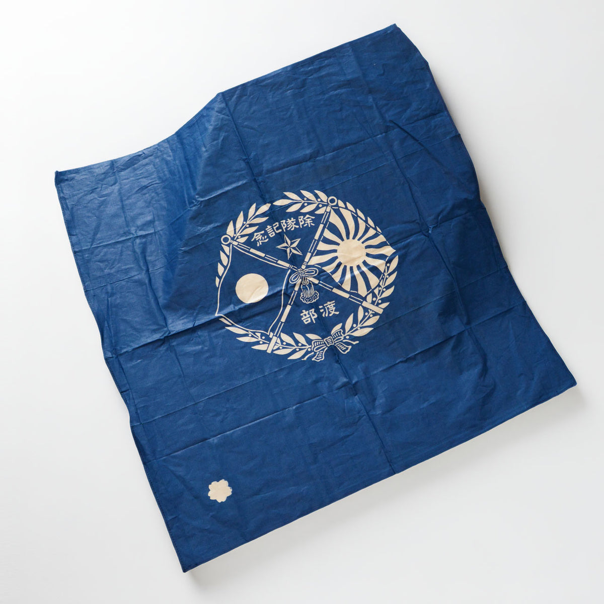 Blue cotton furoshiki with crossed flags, a five-pointed star, laurel wreath, “除隊記念,” “渡部,” and a cherry blossom emblem