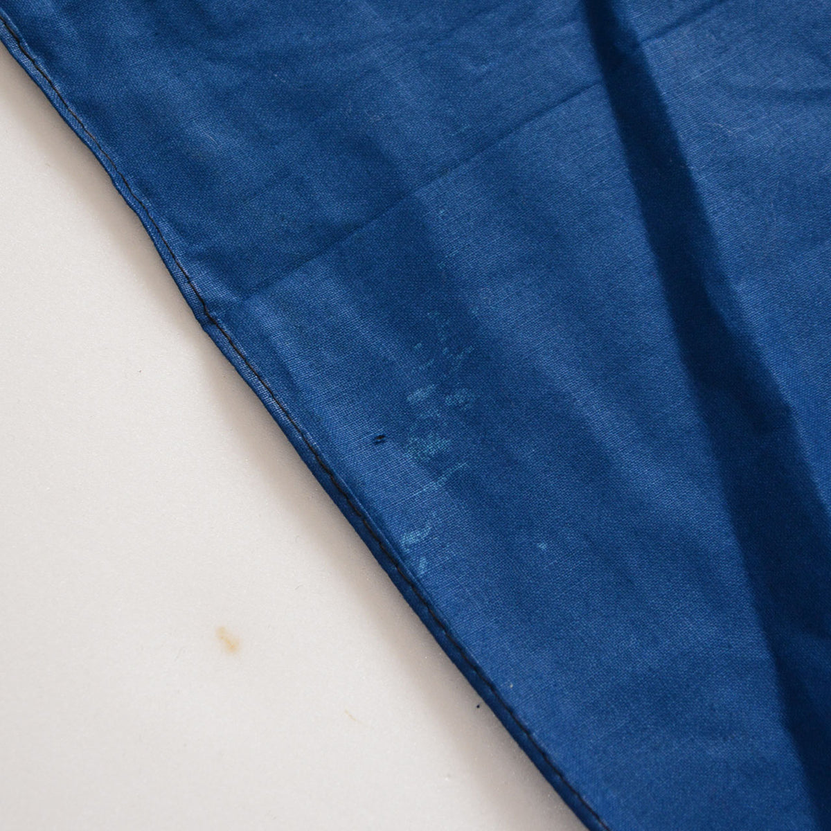 Blue cotton furoshiki with a small hole and faint discoloration near the stitched edge