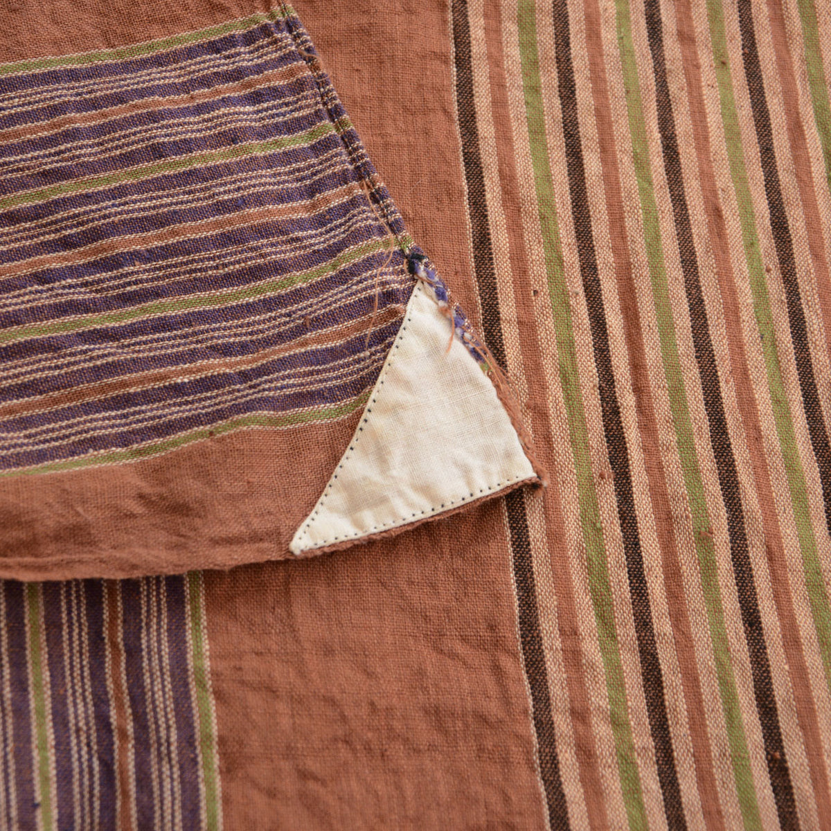 Triangular white cloth sewn into a corner of a mid-Showa cotton furoshiki with fraying around the stitching