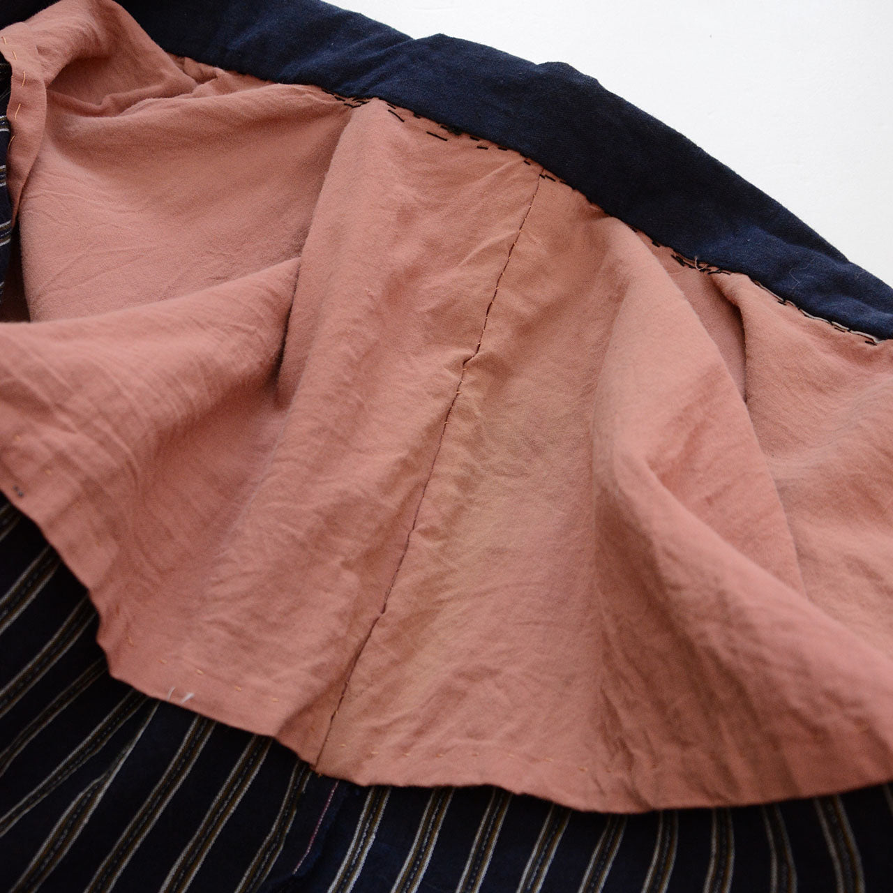 Striped cotton fabric with soft texture and visible hand stitching.