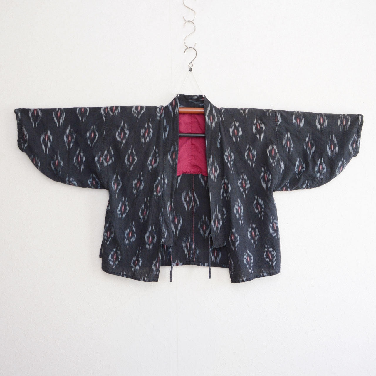 Black-ground noragi in faded cotton with diamond kasuri ikat motifs, maroon lining, Japan vintage