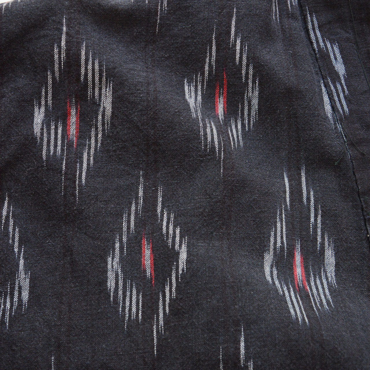 Vintage noragi in black kasuri cotton, eye-like ikat pattern, maroon lining, slow fashion Japan