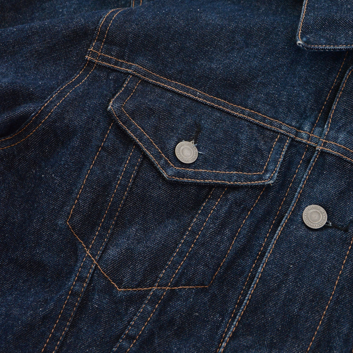 UNIQLO dark indigo denim chest pocket with brown stitching and metal button