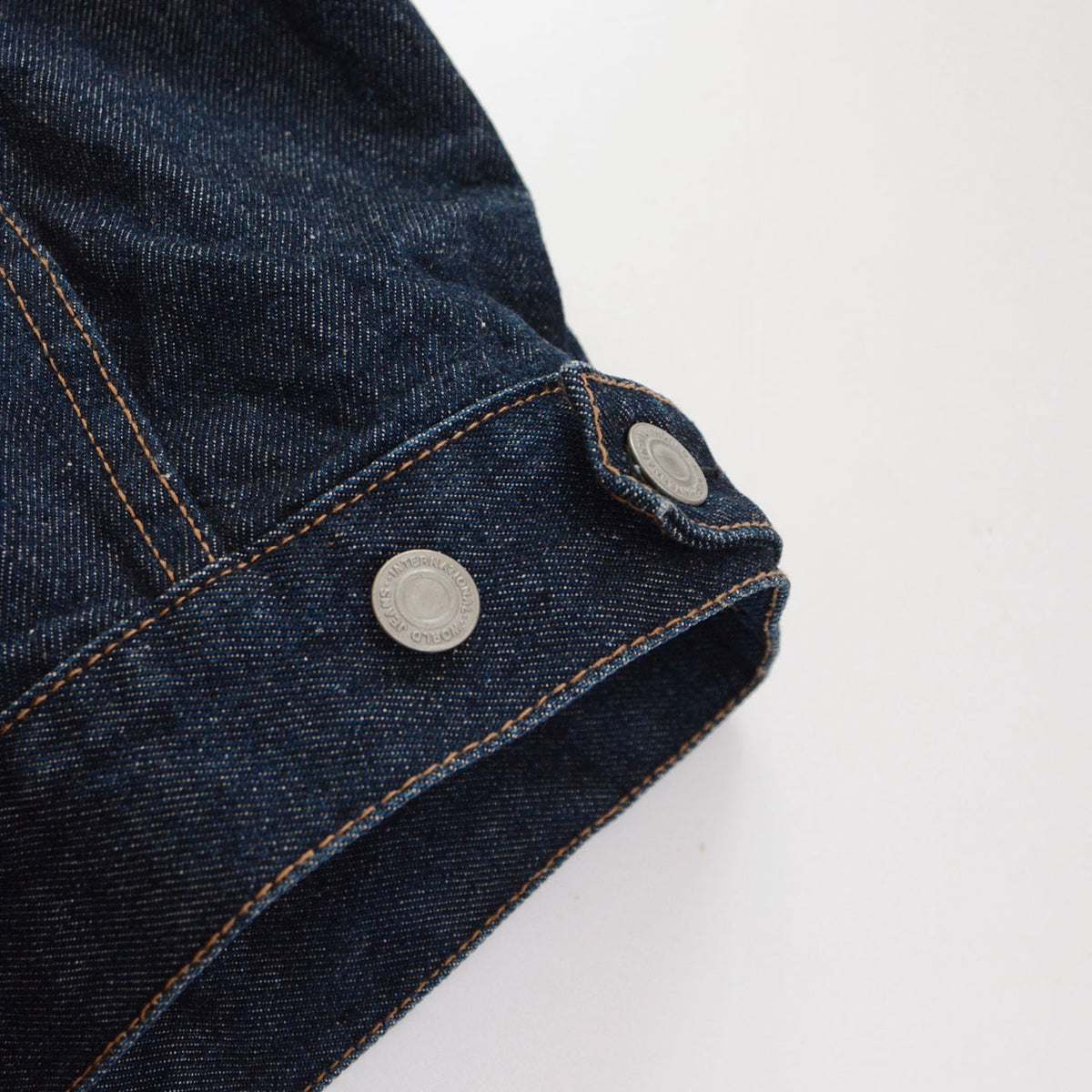 UNIQLO indigo denim jacket waist adjustment tab with two metal buttons