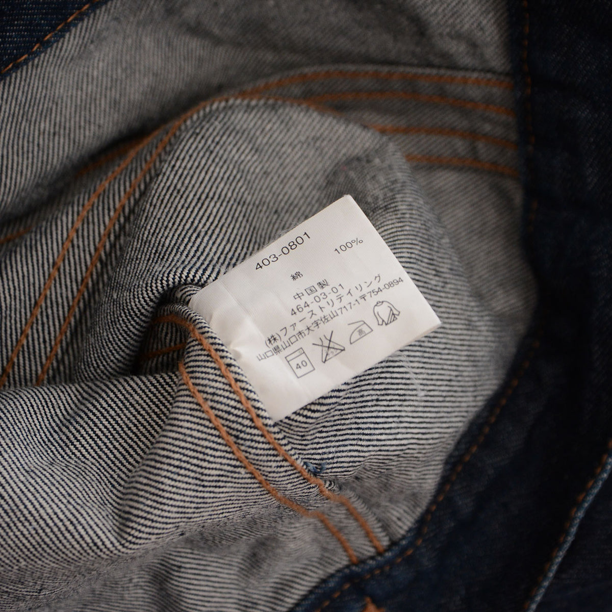 UNIQLO denim jacket care label showing 100 percent cotton and made in China
